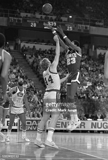 Seattle Supersonics center Mike Green takes a jump shot from the free throw line while Denver Nuggets center Dan Issel defends the shot during an NBA...