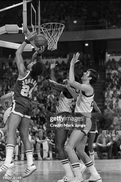 Seattle Supersonics guard Dennis Johnson attempts a layup against Denver Nuggets forwards Paul Silas and Bobby Jones during an NBA basketball game at...