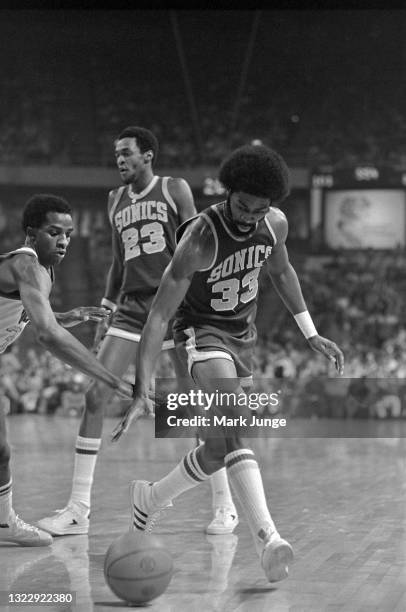 Denver Nuggets forward David Thompson attempts to steal the ball from Seattle Supersonics forward Bob Wilkerson during an NBA basketball game at...