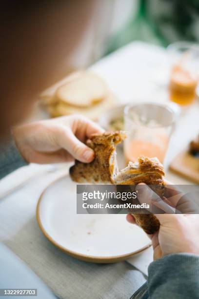 young man enjoys croissant for breakfast - breaking croissant stock pictures, royalty-free photos & images