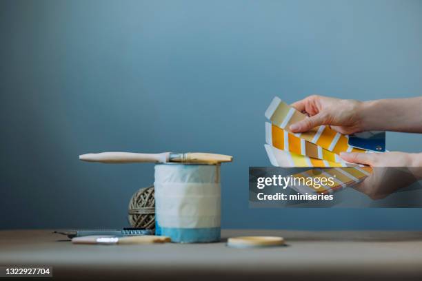 ontsproten van de handen die van de vrouw kleurenpalet houden en gele verf testen - blank can stockfoto's en -beelden