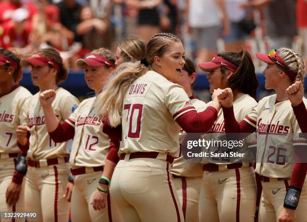 Cassidy Davis of the Florida St. Seminoles high-fives her teammates before the first inning of Game 3 of the Women's College World Series...