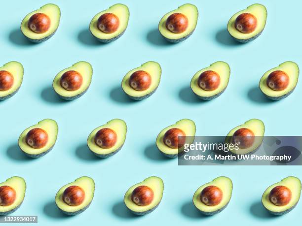 avocado pattern isolated on a blue background - cutting avocado stockfoto's en -beelden