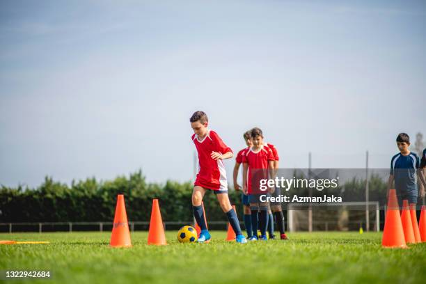 jóvenes futbolistas masculinos haciendo ejercicios de regate - ejercicio de entrenamiento deportivo fotografías e imágenes de stock
