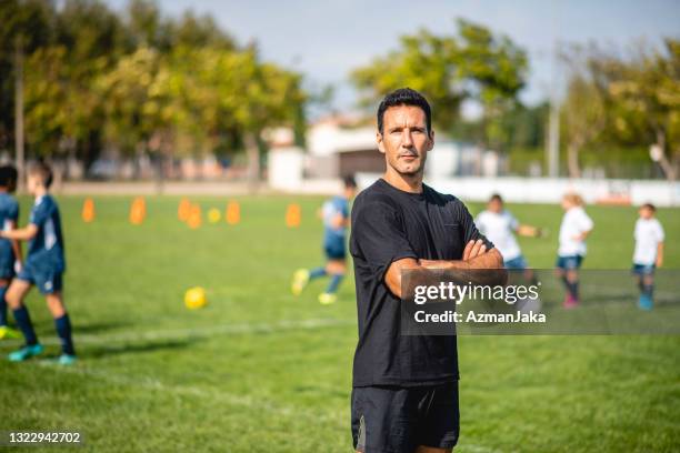 portrait of male footballer coaching mixed age players - football coach stock pictures, royalty-free photos & images