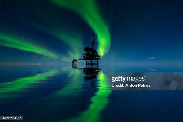 oil platform at sea at the northern lights background. oil production in the north - oil and gas rig fotografías e imágenes de stock