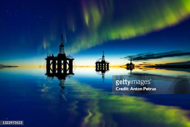 oil platform at sea at the northern lights background. oil production in the north - oil and gas rig fotografías e imágenes de stock