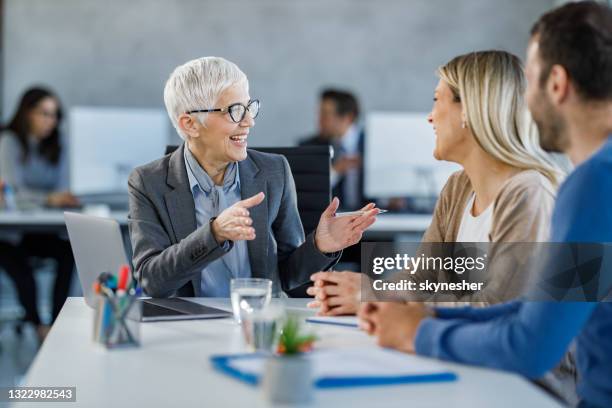 happy insurance agent talking to couple on a meeting in the office. - bankers imagens e fotografias de stock