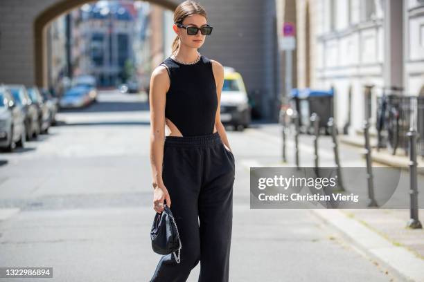 Jacqueline Zelwis is seen wearing ONWEEKENDS black jogger pants, black Leger by Lena Gercke Body, Prada bag, AGL sandals, Gucci sunglasses, Black...