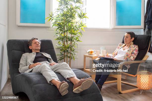 un hombre de 60 años con su psicoterapeuta - psychiatrists couch fotografías e imágenes de stock