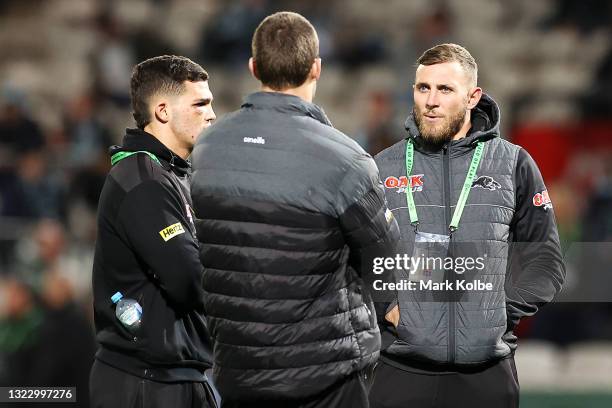 Isaah Yeo, Nathan Cleary and Kurt Capewell speak as they watch on during the warm-up before the round 14 NRL match between the Cronulla Sharks and...