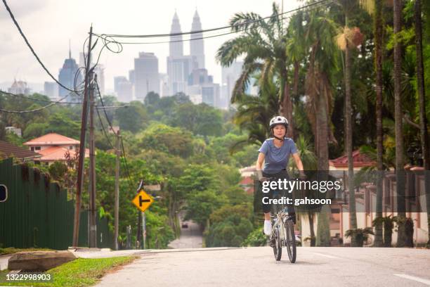 female biker trains on cycling - kuala lumpur road stock pictures, royalty-free photos & images