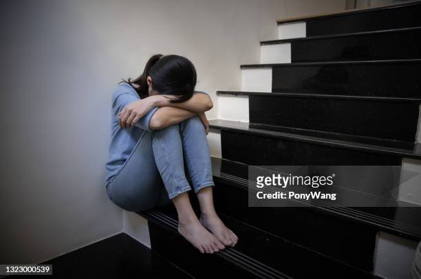 female bullied sit on staircase - abuse victim stock pictures, royalty-free photos & images