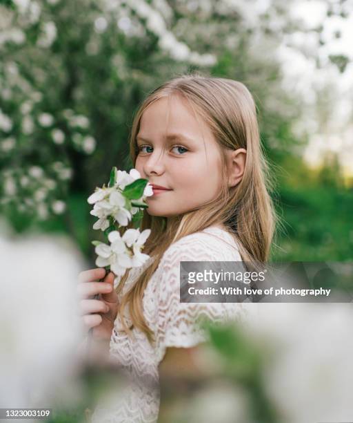 8-10 years old girl walking in spring blooming trees garden - 8 9 years stock-fotos und bilder
