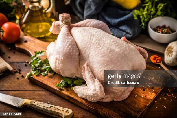 fresh raw chicken on a rustic wooden table. - chickens imagens e fotografias de stock
