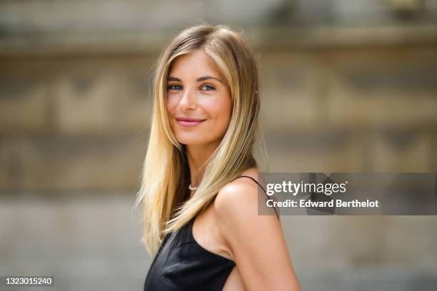 Xenia Adonts wears a black back-nude sleeveless off-shoulder cropped tank top from Paloma, on June 10, 2021 in Paris, France.