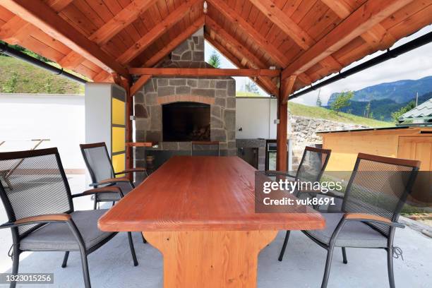 covered patio with chairs and fireplace - outdoor kitchen stock pictures, royalty-free photos & images