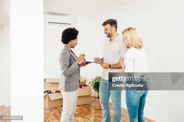 african american real estate agent making a contract with her buyers - condição imagens e fotografias de stock