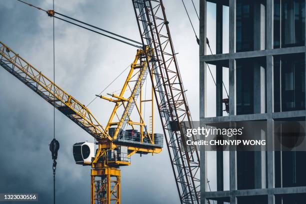 grúas de torre de construcción en una obra de construcción - torre estructura de edificio fotografías e imágenes de stock