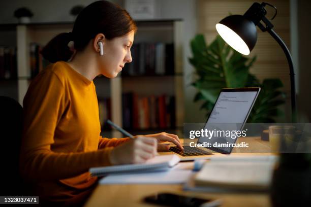 teenager-mädchen mit bluetooth-kopfhörer studieren spät zu hause - forschung teenager stock-fotos und bilder