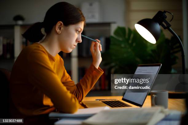 serious teenage girl studying late at home - exam preparation stock pictures, royalty-free photos & images