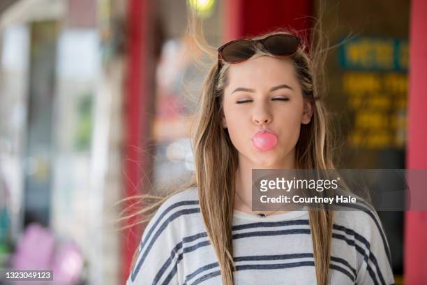 young female blowing a bubble with her bubblegum - chewed stock pictures, royalty-free photos & images