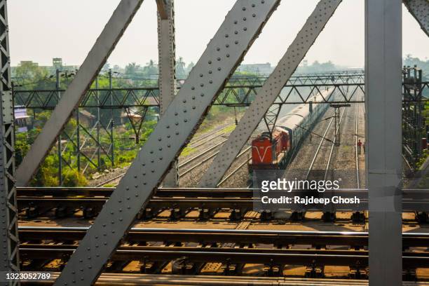 indian railways train passing through bridge - railway bridge stock-fotos und bilder
