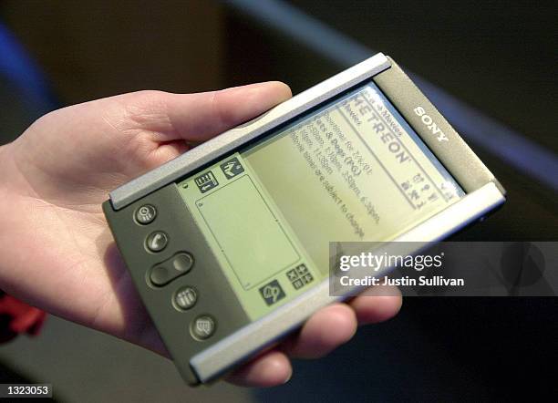 Man points his Personal Digital Assistant towards a beaming station at the Sony Metreon July 6, 2001 in San Francisco, CA. These beaming station...