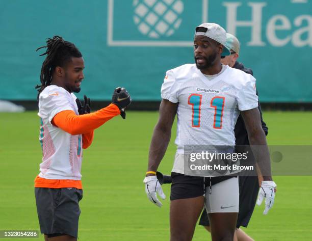 Wide Receiver Jaylen Waddle of the Miami Dolphins speaks with Wide Receiver DeVante Parker during off-season workouts at Baptist Health Training...
