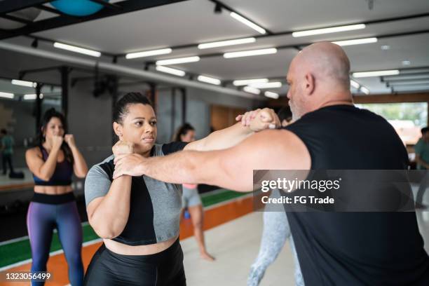 intructor defendiéndose durante el entrenamiento de boxeo en el gimnasio - self defense fotografías e imágenes de stock