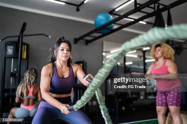 mature woman working out with battle ropes at the gym - circuit training stock pictures, royalty-free photos & images