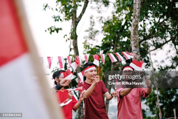 el pueblo indonesio celebra el día de la independencia de indonesia - bandera indonesia fotografías e imágenes de stock