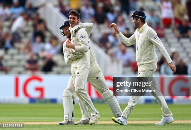 Dan Lawrence of England celebrates taking the wicket of Will Young of New Zealand with team mates James Bracey and Dominic Sibley during day two of...