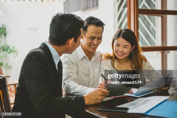 happy asian couple signing contract agreement from real estate agent - service agreement stock pictures, royalty-free photos & images