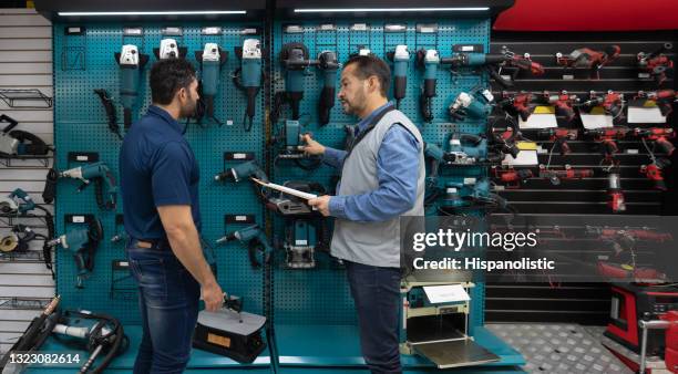 client achetant des outils dans une quincaillerie et parlant à un vendeur - outil de bricolage photos et images de collection