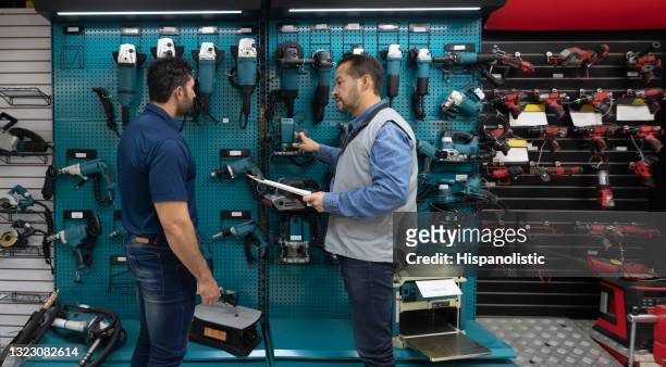 acquisto di strumenti da parte dei clienti in un negozio di ferramenta e parlare con un venditore - hand tool foto e immagini stock