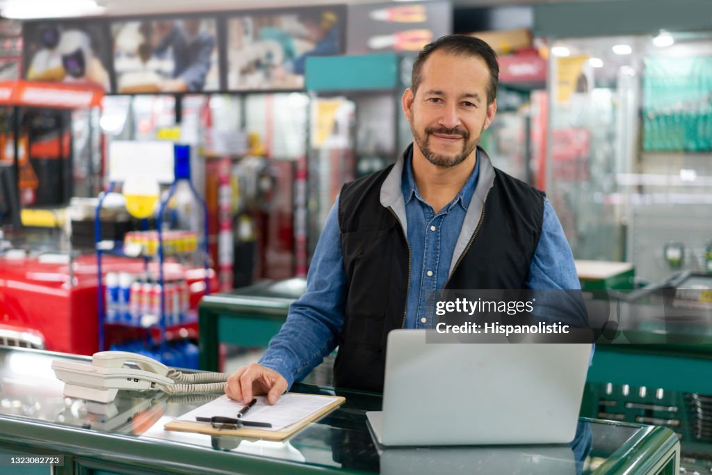 Business manager looking happy working at a hardware store