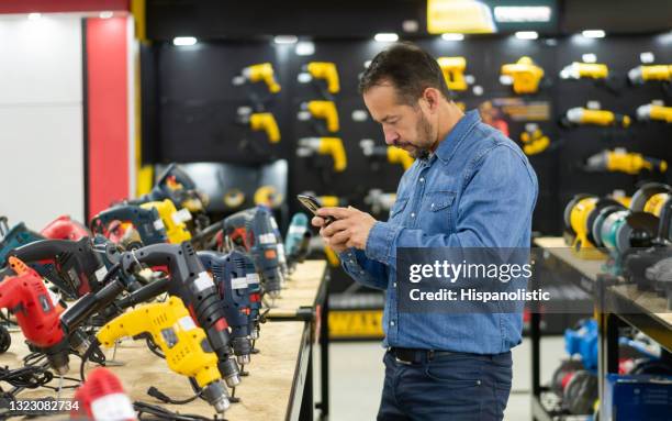 mann beim einkaufen in einem baumarkt und fotografieren die werkzeuge - hardware shop stock-fotos und bilder