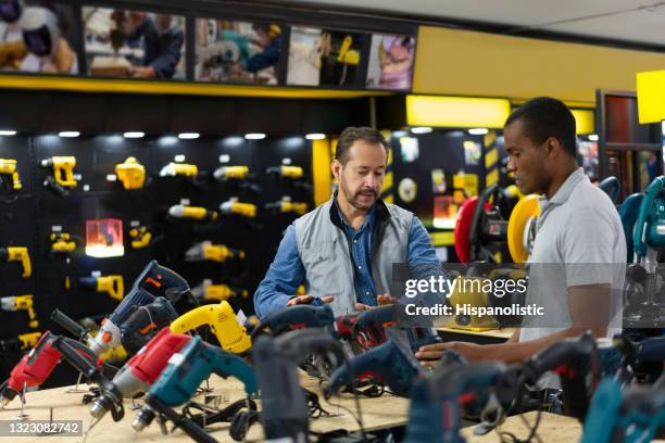 venditore che aiuta un uomo ad acquistare strumenti in un negozio di ferramenta - salesman foto e immagini stock