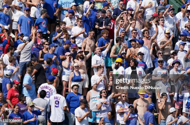 Fans in the left field bleachers celebrate after the two-run double by Joc Pederson of the Chicago Cubs during the seventh inning of a game against...