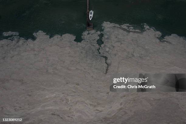 In an aerial view, a boat is seen docked at a jetty amid 'sea snot' on the Marmara Sea, on June 11, 2021 in Kocaeli, Turkey. The coastline of...