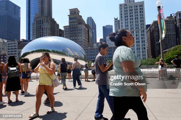 People visit Anish Kapoor's Cloud Gate sculpture on June 11, 2021 in downtown Chicago, Illinois. Today Chicago and the rest of the state of Illinois...