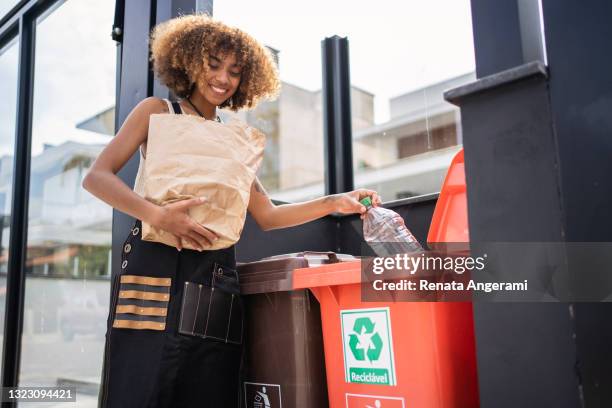 afroamerikanische junge frau recycling müll. nachhaltigkeitskonzept. - recycling stock-fotos und bilder