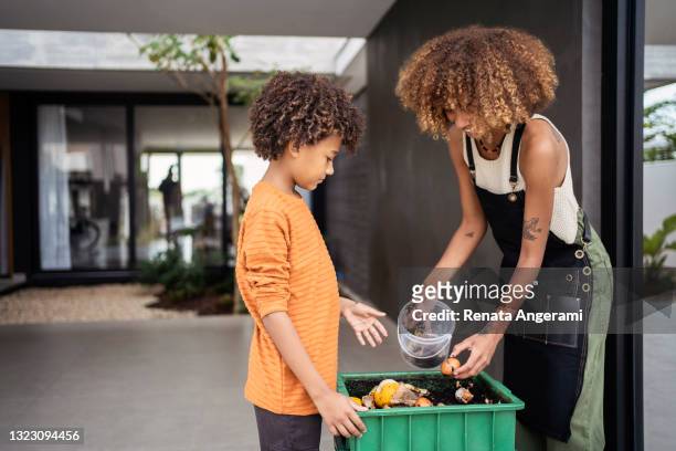 die afroamerikanische junge frau und ihr jüngerer bruder machen kompost aus resten. nachhaltigkeitskonzept. - kompost stock-fotos und bilder