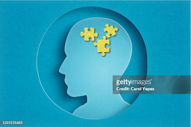 paper head with puzzle pieces-autism concept.blue background - erinnerung stock-fotos und bilder