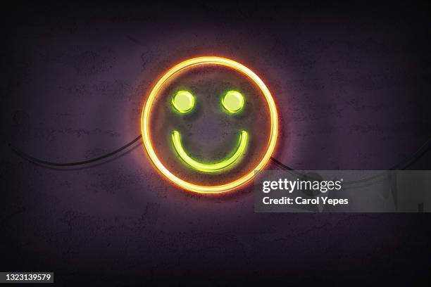 smile face in neon  lights agains dark wall - happy face stock pictures, royalty-free photos & images