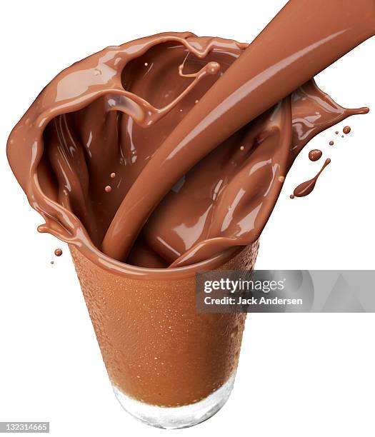 glass of chocolate milk splashing. - chocolate milk stock pictures, royalty-free photos & images