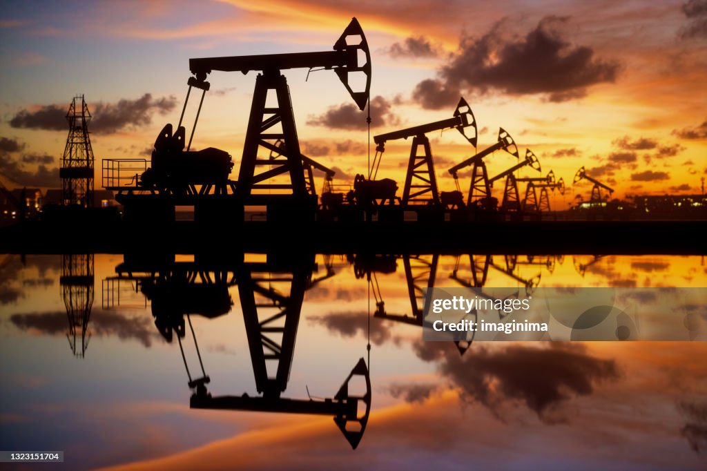 Bombas de aceite y plataforma al atardecer junto al mar