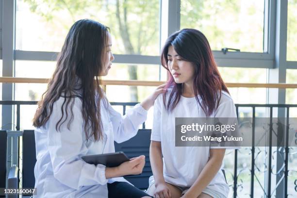 a female psychologist is comforting a girl - mental disorder imagens e fotografias de stock