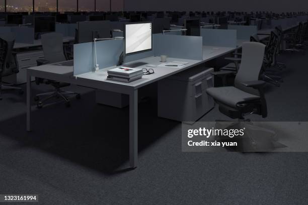 illuminated computer on desk in darkroom at office - office cubicle stock-fotos und bilder